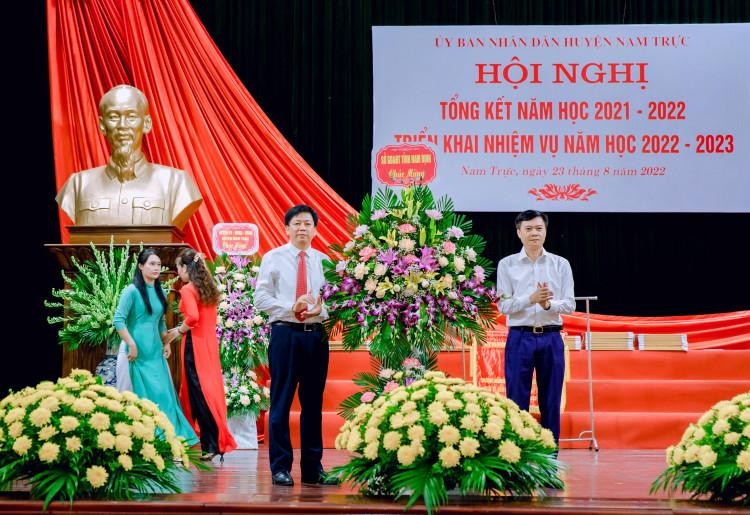 Phó Giám đốc Sở GD&ĐT Nam Định Nguyễn Xuân Hồng (bìa phải) tặng hoa chúc mừng những thành tích của ngành giáo dục huyện Nam Trực trong năm học vừa qua. 