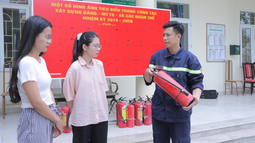 Cán bộ Cảnh sát PCCC&CNCH - Công an huyện Hoài Đức hướng dẫn người dân cách sử dụng phương tiện chữa cháy tại chỗ. Ảnh: Đình Tuệ.