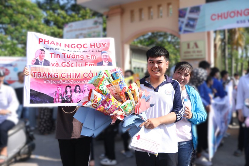 Nam sinh Phan Ngọc Huy được gia đình tặng một bó hoa "siêu to khổng lồ" bằng các loại bánh kẹo, bim bim, xúc xích để chúc mừng em đã hoàn thành kỳ thi năm nay. Ảnh: Đình Tuệ.