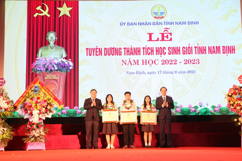 Thứ trưởng Phạm Ngọc Thưởng (bìa phải) và Bí thư Tỉnh ủy Nam Định Phạm Gia Túc tặng Bằng khen của Bộ GD&ĐT cho các em học sinh tiêu biểu xuất sắc của tỉnh Nam Định. 