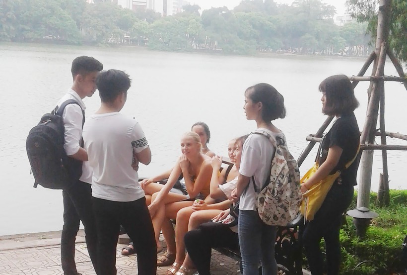 Nhóm bạn trẻ đang giao lưu học hỏi tiếng Anh từ nhóm du khách nước ngoài tại Hồ Gươm