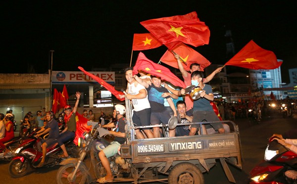 Xe ba gác chở kín người ăn mừng chiến thắng của tuyển Việt Nam trong trận bán kết với Philippines. (Ảnh: TTXVN)

