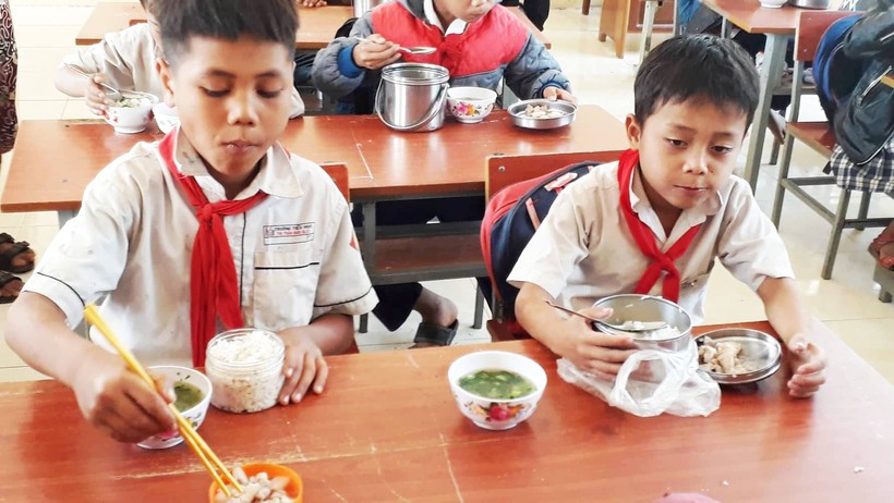 Các em học sinh đồng bào Hà Lăng ăn uống ngon lành sau giờ học.

