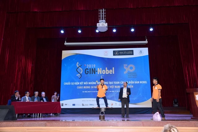 Ts. Phan Quốc Việt (giữa) và kỷ lục gia 9 tuổi Nguyễn Đình Khánh Hưng tại sân khấu “Diễn đàn Nobel năm 2019”.