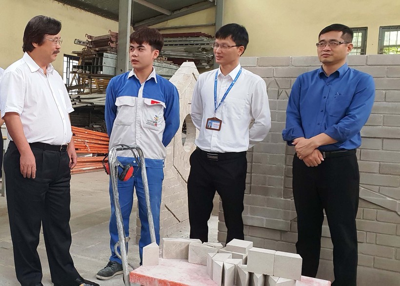 Ông Nguyễn Hồng Minh (bên trái) trao đổi với chuyên gia và thí sinh nghề xây gạch