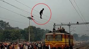 Người đàn ông trèo lên cột điện rồi đứng trên đường dây. 