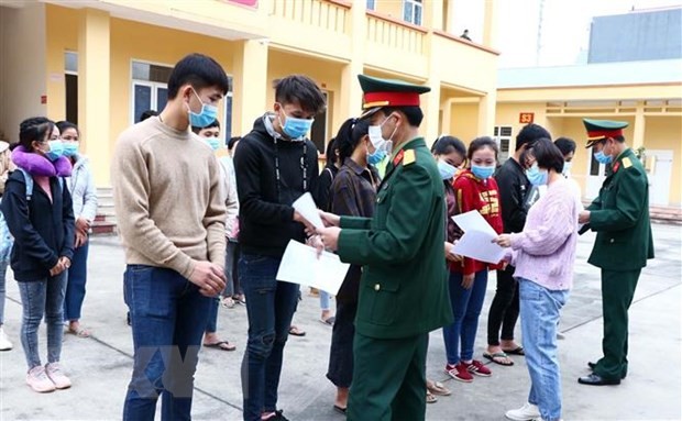 Cán bộ Bộ Chỉ huy Quân sự và Sở Y tế tỉnh Hòa Bình trao giấy chứng nhận hoàn thành thời gian cách ly y tế tập trung cho sinh viên Lào. (Ảnh: Thanh Hải/TTXVN).