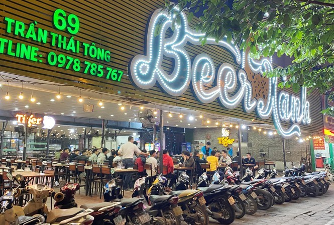 Nhiều khách đến quán "Beer Xanh" ở Trần Thái Tông và để xe máy thành hàng dài trên vỉa hè. Ảnh: Trọng Tài