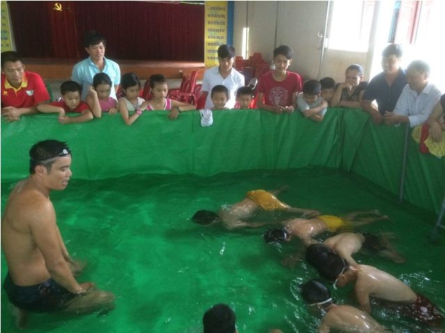 Các em học sinh học bơi tại bể bơi mini