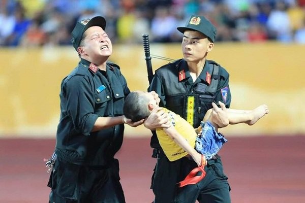 Các chiến sĩ cảnh sát cơ động trên sân Thiên Trường giúp một cháu bé bị co giật đi cấp cứu. 