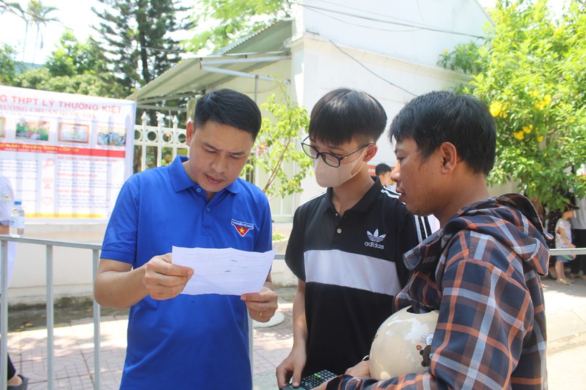 Thầy Hoàng Quốc Hải (áo xanh), giáo viên Trường THCS Quảng Hưng trao đổi về đề thi với học trò bên ngoài khu vực thi Trường THPT Tô Hiến Thành (TP Thanh Hóa). Ảnh: LT.