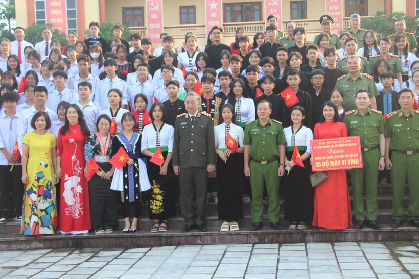 Bộ trưởng Tô Lâm, lãnh đạo Bộ Công an, Công an tỉnh Điện Biên chụp ảnh lưu niệm cùng thầy trò 2 trường học được nhận máy tính.