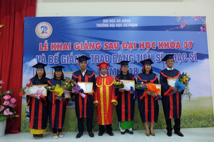 PGS.TS Võ Văn Minh - Phó Hiệu trưởng Trường ĐH Sư phạm (ĐH Đà Nẵng) trao bằng tốt nghiệp và tặng hoa chúc mừng các tân tiến sĩ, thạc sĩ.
