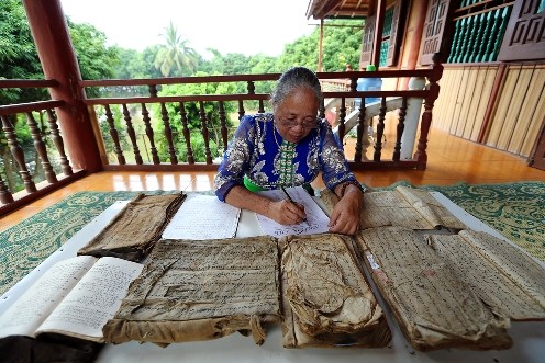 Nghệ nhân Ưu tú Lương Thị Đại nghiên cứu và sưu tầm chữ Thái cổ