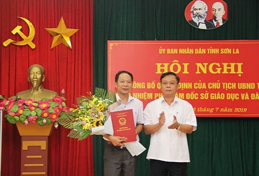 Ông Cầm Văn An (bên trái) nhận Quyết định và hoa chúc mừng