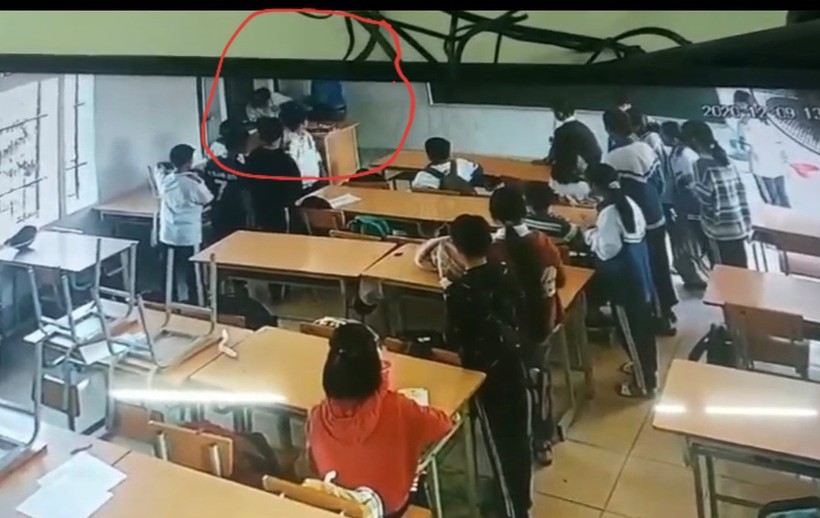 Vị phụ huynh côn đồ (áo xanh) đang tấn công học sinh mặc đồng phục được camera ghi lại