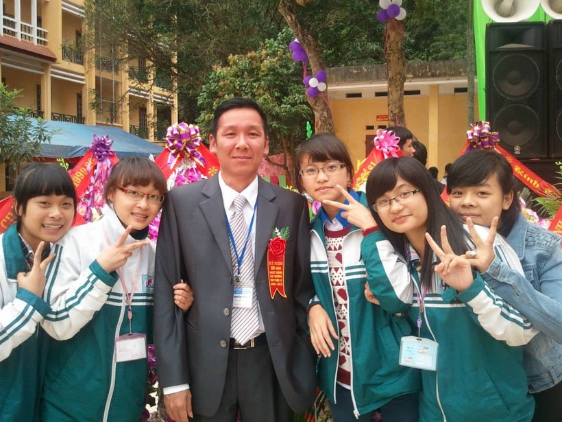 Thầy giáo Nguyễn Minh Hải (đứng giữa) chụp ảnh lưu niệm cùng học sinh (Ảnh tư liệu)