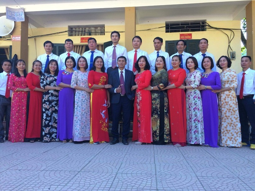Thầy Nguyễn Hữu Dũng (áo đen đứng giữa) chụp ảnh lưu niệm cùng tập thể giáo viên toàn trường.