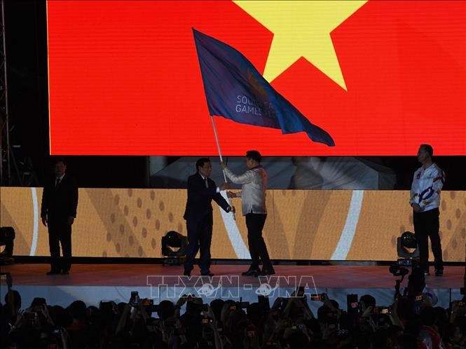 Bộ trưởng Bộ Văn hóa, Thể thao và Du lịch Việt Nam Nguyễn Ngọc Thiện (trái) đã nhận cờ đăng cai kỳ SEA Games 31 từ Chủ tịch Ủy ban Olympic Philippines Bambol Tolentino (phải) tại lễ bế mạc SEA Games 30, ngày 11/12/2019. Ảnh: AFP/TTXVN.