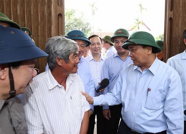 Thủ tướng Nguyễn Xuân Phúc đến thăm hỏi ông Cao Văn Phụng, tại thôn An Hà 1, xã Nghĩa Trung, huyện Tư Nghĩa. (Ảnh: Thống Nhất/TTXVN).