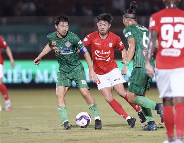 Pha tranh bóng giữa các cầu thủ đội Thành phố Hồ Chí Minh (áo đỏ) và đội Sài Gòn FC. (Ảnh: Thanh Vũ/TTXVN).