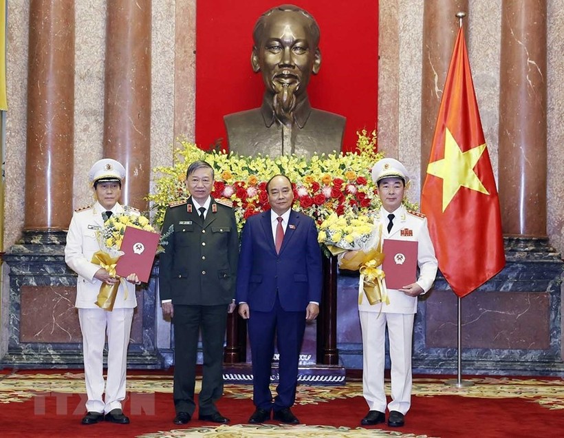 Chủ tịch nước Nguyễn Xuân Phúc, Đại tướng Tô Lâm chúc mừng Thứ trưởng Bộ Công an Trần Quốc Tỏ và và Lương Tam Quang được thăng cấp bậc hàm từ Trung tướng lên Thượng tướng. Ảnh: TTXVN.