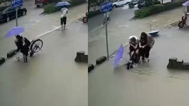 Trung Quốc: Mưa lớn ngập đường, đang đạp xe người phụ nữ cắm đầu xuống hố