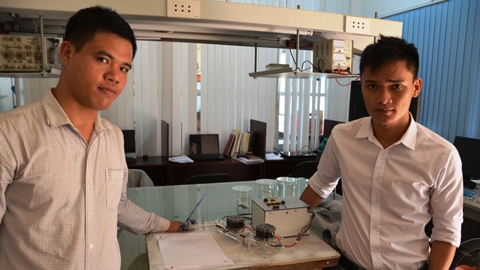 Trần Hữu Tân (trái) và Nguyễn Trọng Minh cùng với robot vẽ tranh
