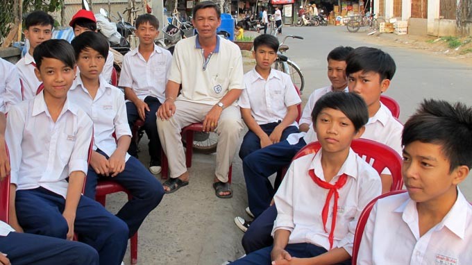 Ông Lê Phát Phước (giữa) và các em học sinh từng mê game được ông kéo về lớp học 