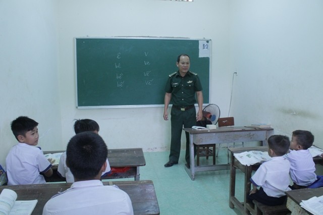  Thiếu tá Nguyễn Văn Chính (Đồn Biên phòng Bến Phố) dạy chữ cho trò.