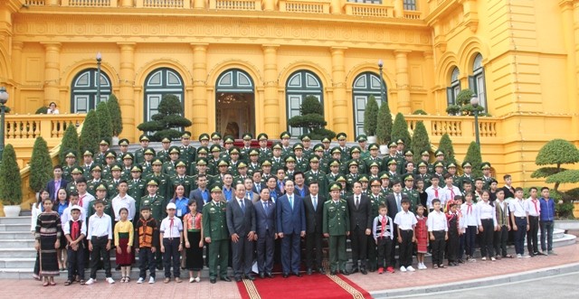 Chủ tịch nước Trần Đại Quang chụp ảnh cùng các thầy giáo quân hàm xanh và các em học sinh.