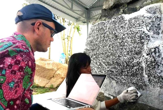 Giáo sư Arlo Griffiths nghiên cứu dòng chữ khắc trên bia đá Chăm Pa. Ảnh Nguyễn Quang Tuệ.
