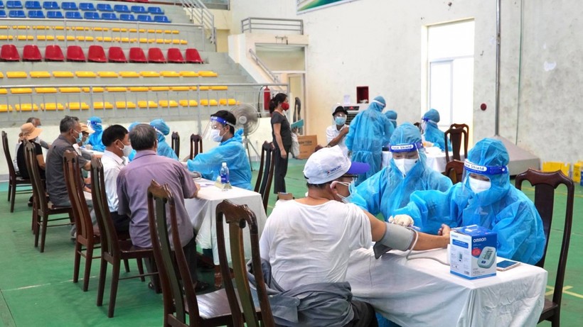 Các nhân viên y tế kiểm tra sức khỏe trước khi tiêm vắc xin ngừa Covid-19 cho người được tiêm trên địa bàn tỉnh Quảng Bình.