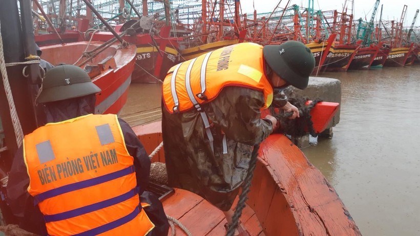 Bộ đội biên phòng Quảng Bình hỗ trợ người dân đưa tàu thuyền vào khu vực tránh trú an toàn.
