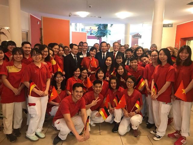 Bộ trưởng Bộ LĐ-TB&XH Đào Ngọc Dung chụp ảnh lưu niệm với các điều dưỡng viên Việt Nam tại Đức