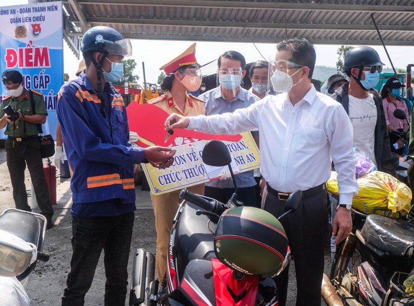 Ông Nguyễn Văn Quảng - Bí thư Thành ủy Đà Nẵng (áo sơ mi trắng) trao tặng xe máy cho người dân khó khăn trên đường đi về quê. 
