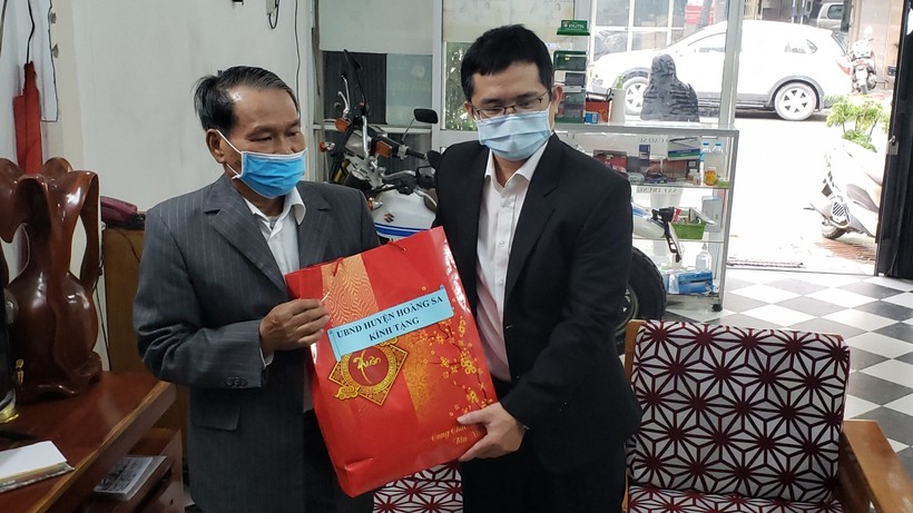 Đại diện lãnh đạo UBND huyện Hoàng Sa (TP Đà Nẵng) thăm và tặng quà cho ông Lê Đình Rê (bên trái). 