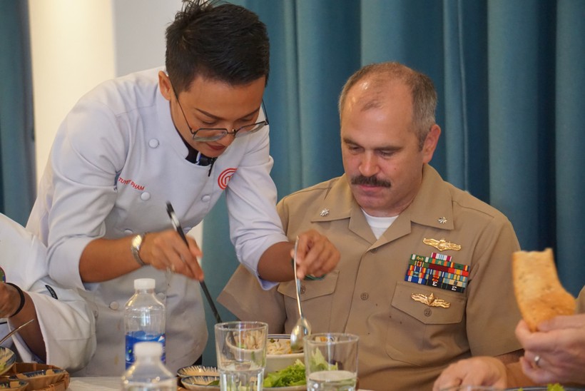 Đầu bếp Việt Nam hướng dẫn một sĩ quan của Hải quân Hoa Kỳ cách thưởng thức món mỳ Quảng. Ảnh: Vinh Hoàng. 