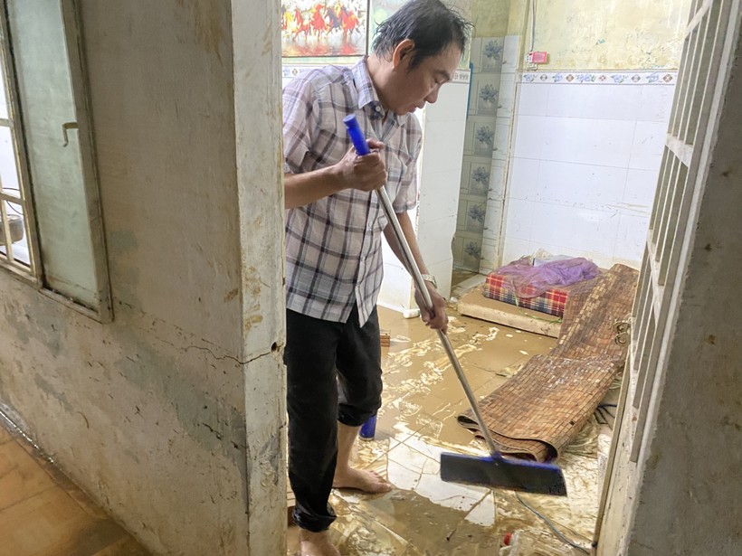 Ông Tuấn đang dọn dẹp bùn non sau 2 trận lụt. (Ảnh: Hoàng Vinh)