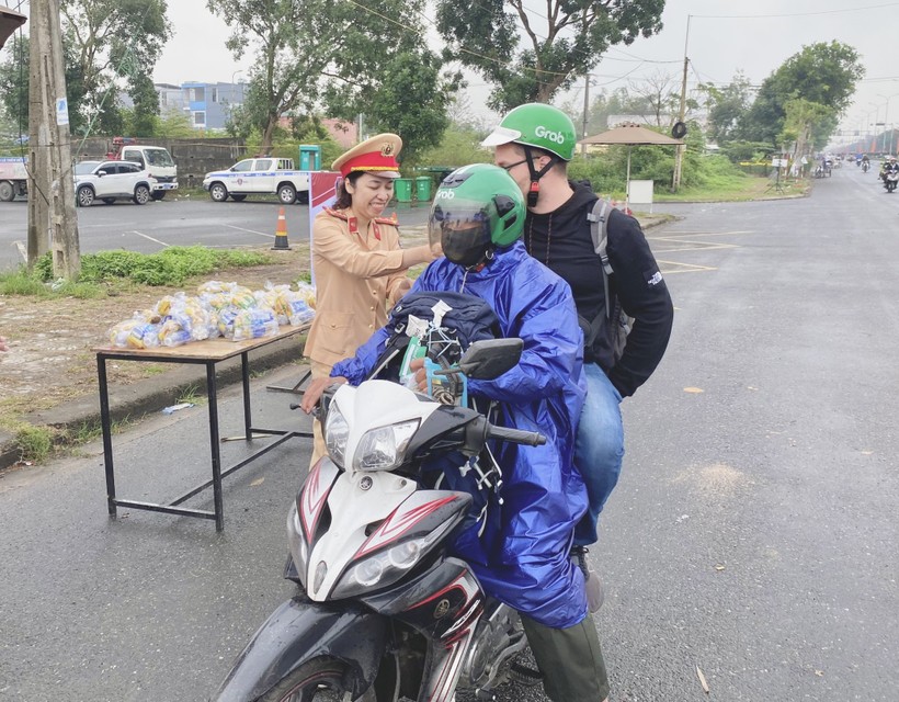 Lực lượng CSGT Công an TP Đà Nẵng tặng nước và thức ăn cho người dân đang trên hành trình về quê đón Tết. 