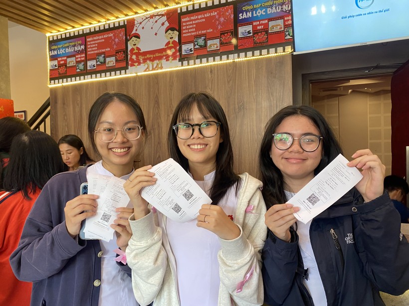 Quỳnh Nhi (ở giữa) cùng 2 người bạn tươi cười sau khi mua được 6 tấm vé xem phim.