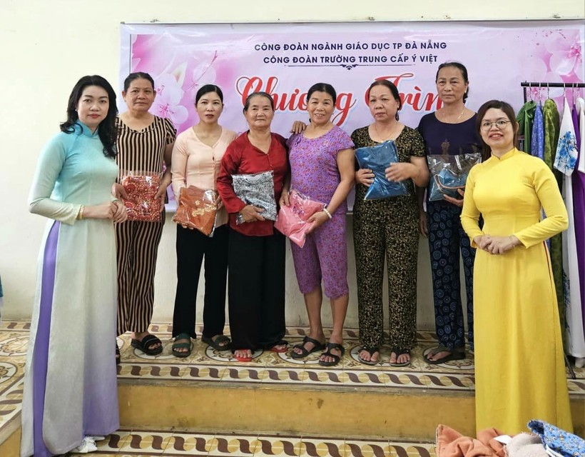 Đại diện Trường Trung cấp Ý Việt tặng áo dài cho phụ nữ là công nhân, nông dân. 