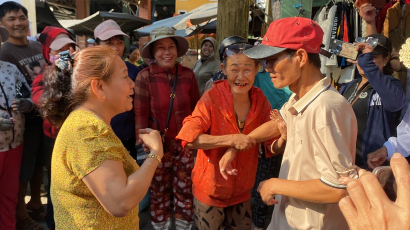 Hàng xóm vui mừng đón anh Chung (đội mũ đỏ) trở về quê sau 18 năm lưu lạc ở Trà Vinh. 