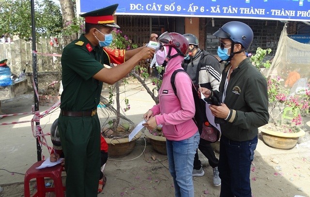Lực lượng bộ đội tại chốt kiểm tra khai báo y tế, đo thân nhiệt và rửa tay (ảnh Cổng TTĐT Cà Mau).