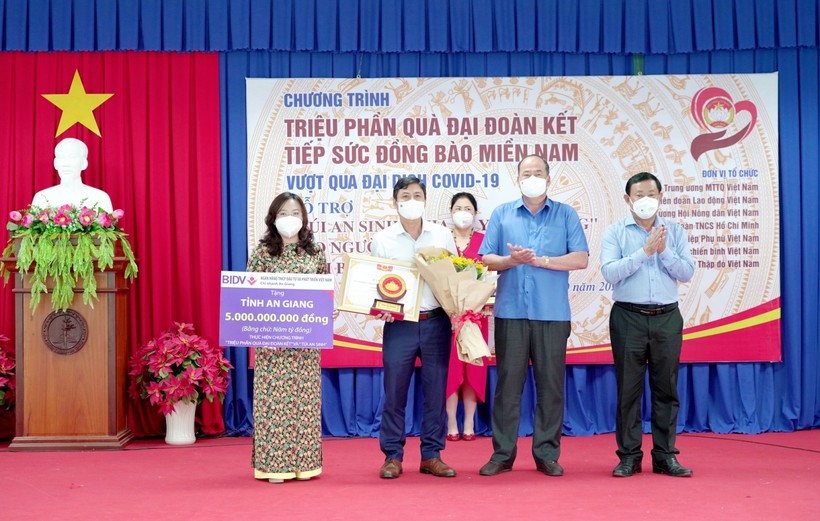 Chủ tịch UBND tỉnh An Giang (người thứ 2 từ phải sang) tặng hoa cho đại diện doanh nghiệp.