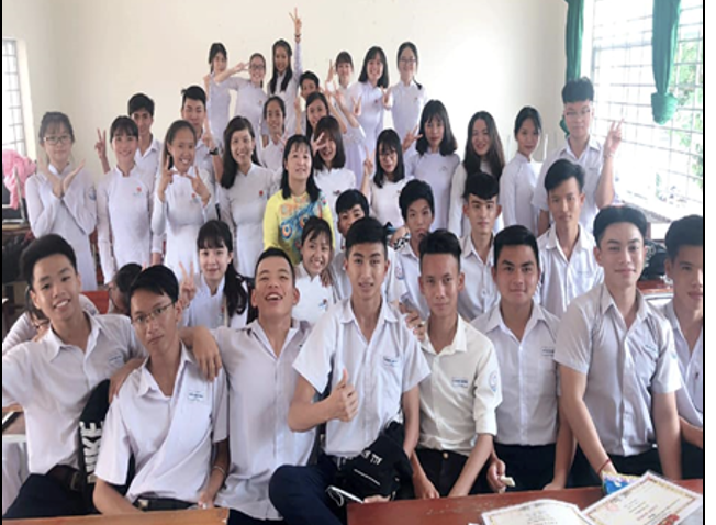 Cô giáo Nguyễn Thị Diễm (áo vàng) chụp ảnh lưu niệm cùng học trò Trường THPT Bùi Hữu Nghĩa.