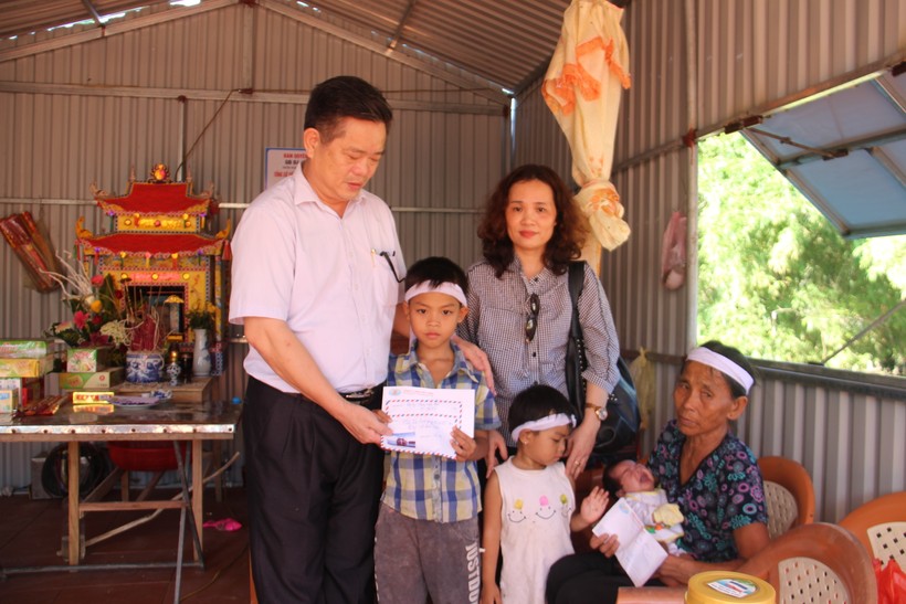 Ông Hoàng Trung Thông, tổng tư ký Hiệp hội Doanh nghiệp Hà Tĩnh (bên trái) trao 12 triệu đồng cho gia đình bà Trịnh Thị Tư