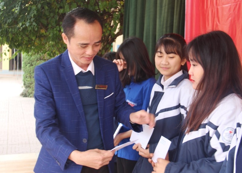 Thầy Nguyễn Văn Quang, Hiệu trưởng Trường THPT Cẩm Bình trao quà cho các em học sinh.