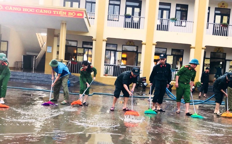 Lực lượng công an huyện Thạch Hà hỗ trợ giáo viên Trường tiểu học Thạch Đài dọn vệ sinh trường lớp sau khi nước lũ rút.