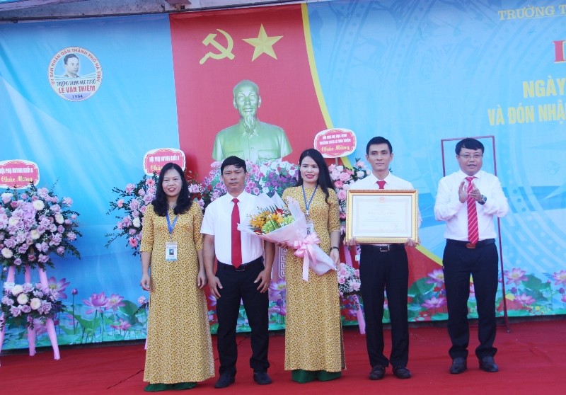 Thừa quyền Chủ tịch nước CHXHCN Việt Nam, Bí thư Thành ủy Dương Tất Thắng (bên phải) trao Bằng công nhận Huân chương Lao động hạng Nhất cho nhà trường.